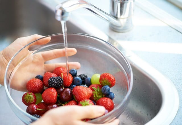 rửa các loại quả mọng dưới vòi nước